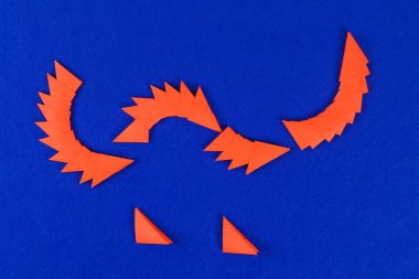 Mavi arka plan DIY Çince Ejderha. Hediye fikirleri, dekor Çin yeni yılı. El yapımı kırmızı altın ay ejderha aslandan Modüler origami. Adım adım. El sanatları işlemidir. Üstten görünüm.