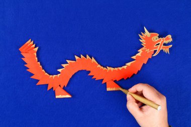 Mavi arka plan DIY Çince Ejderha. Hediye fikirleri, dekor Çin yeni yılı. El yapımı kırmızı altın ay ejderha aslandan Modüler origami. Adım adım. El sanatları işlemidir. Üstten görünüm.
