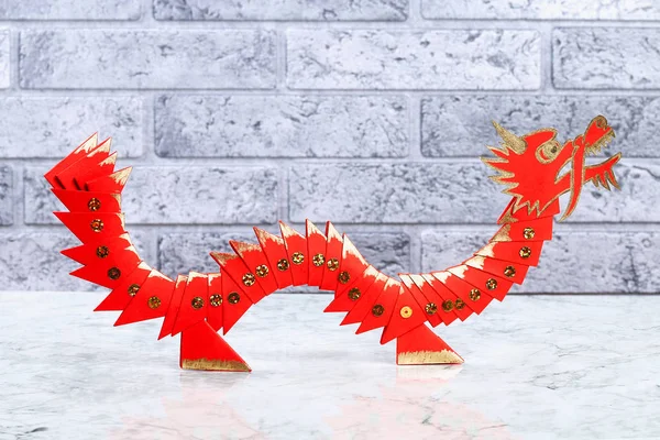 Diy chinese dragon on wall background. Gift ideas, decor Chinese new year. Handmade red gold lunar dragon lion from modular origami. Step by step. The process of crafts.