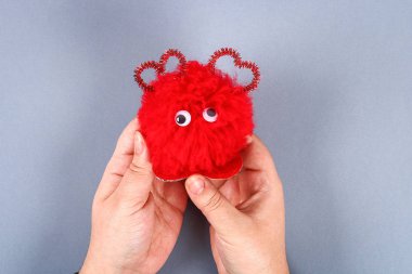 Kırmızı el yapımı DIY canavar pom pom gelen iplik Şönil şekil kalbinde kaynaklanıyor. Sevgililer günü, aşk, kavramı, 14 Şubat günü için hediye fikirleri. Adım adım. Çocuk el sanatları işlemidir. Üstten görünüm.