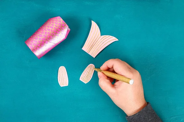 Mavi yeşil arka planda Diy koi sazan balığı. Çin yeni yılı için hediye fikirleri, dekor. Çocuk el yapımı. Sazan balığı kağıdı, tuvalet kağıdı, şaşı gözler. Adım adım. Çocuk işçiliğini işleyin. Üst görünüm.