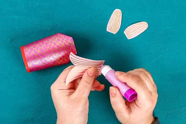 Mavi yeşil arka planda Diy koi sazan balığı. Çin yeni yılı için hediye fikirleri, dekor. Çocuk el yapımı. Sazan balığı kağıdı, tuvalet kağıdı, şaşı gözler. Adım adım. Çocuk işçiliğini işleyin. Üst görünüm.