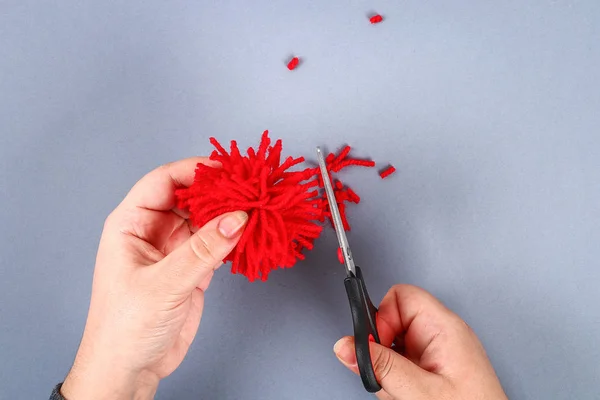Kırmızı el yapımı DIY canavar pom pom gelen iplik Şönil şekil kalbinde kaynaklanıyor. Sevgililer günü, aşk, kavramı, 14 Şubat günü için hediye fikirleri. Adım adım. Çocuk el sanatları işlemidir. Üstten görünüm.
