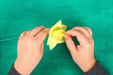 DIY bahar çiçekleri nergis yeşil zemin üzerine sarı kağıt. Hediye fikirleri, dekor bahar, Paskalya için. El yapımı. Adım adım. El sanatları işlemidir. Üstten görünüm. Çocuk Paskalya el sanatları.