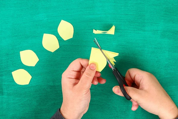染春花水仙花的黄纸上有绿色的背景 礼物的想法 春天的装饰 复活节 一步一步 工艺的过程 顶部视图 儿童复活节工艺品 — 图库照片