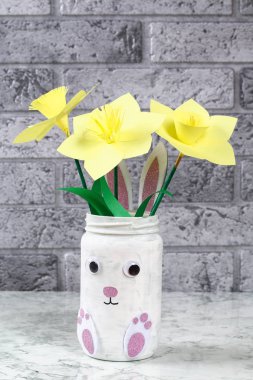 Cam kavanoz, keçe, pörtlek gözlü yeşil bir arka plan üzerinde DIY Paskalya vazo bunny. Hediye fikirleri, dekor bahar, Paskalya için. El yapımı. Adım adım. El sanatları işlemidir. Üstten görünüm. Çocuk Paskalya el sanatları.