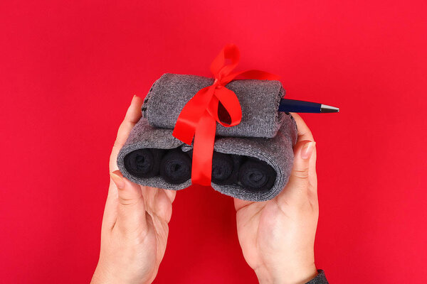 Diy бак носков на красном фоне. Подарок отцу, мужу, брату, бабушке к 23 февраля, Дню защитника Отечества, 9 мая. Сделано вручную. Шаг за шагом. обрабатывать детские ремесла. Вид сверху
.