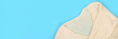 Afiş. Beyaz yün giyim kadar kapatın. Üstten görünüm. Pastel mavi tablo yüzey arka plan. Kopya alanı