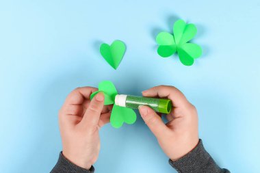DIY yeşil yonca St Patricks Günü mavi zemin üzerine. Hediye fikri, dekor Saint Patricks Day. Yonca yeşil kağıt ve tel. Adım adım. Çocuk zanaat süreç. Üstten görünüm. İrlandalı tatil. Şanslı yonca.