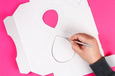 DIY sekiz yapılmış karton dekore edilmiş yapay çiçek mavi dokulu kağıt peçete pembe arka plan yaptı. Hediye fikri, dekor Uluslararası Kadınlar günü, Mart 8. Adım adım. Üstten görünüm. Süreci çocuk zanaat.