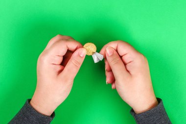 DIY altın sikke ve parlak yeşil arka plan üzerinde St Patricks Günü kağıt. Hediye fikri, dekor cin için tuzak Saint Patricks Day. Adım adım. Çocuk çocuk zanaat süreç. Üstten görünüm. İrlandalı tatil.