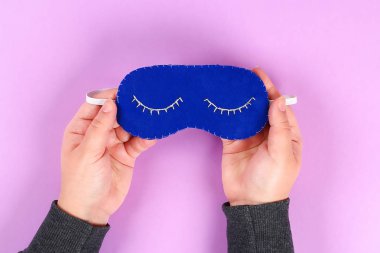 DIY mavi beyaz iplik kirpik sakız mor arka planda üzerinde kapalı gözlerle işlemeli ile uyku maskesi hissettim. Dikiş, dikiş. Hediye fikri, dekor. Adım adım. Üstten görünüm. Uykusuzluk.