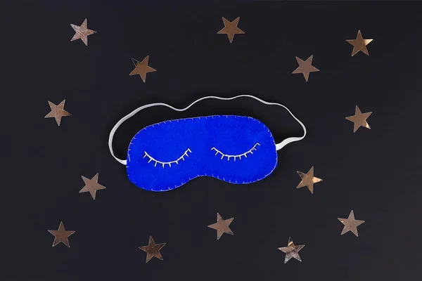 Sleeping mask handmade made of felt, stars on a black background. Flat lay. Top view. Kid craft. Children diy.