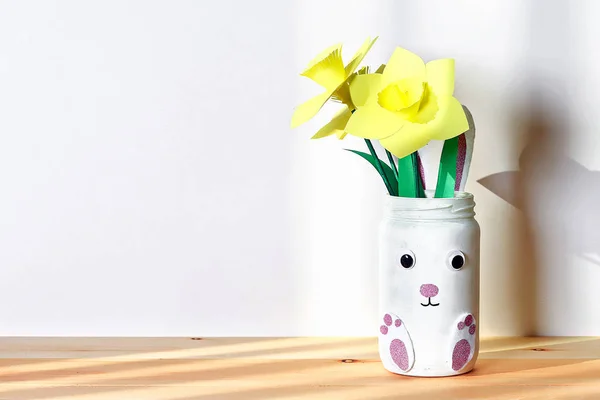 DIY conejito jarrón de Pascua con narciso, narcisos de frasco de vidrio, fieltro, ojos sobre fondo blanco de la pared — Foto de Stock