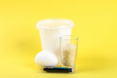 DIY Paskalya yortusu yumurta sarı bir arka plan üzerinde renkli pilav ile boyalı. Yumurta Paskalya için dekor