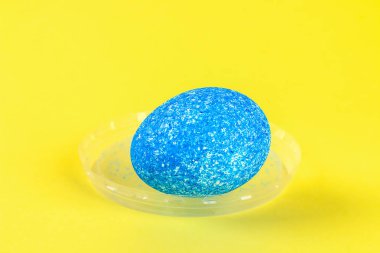 DIY Paskalya yortusu yumurta sarı bir arka plan üzerinde renkli pilav ile boyalı. Yumurta Paskalya için dekor