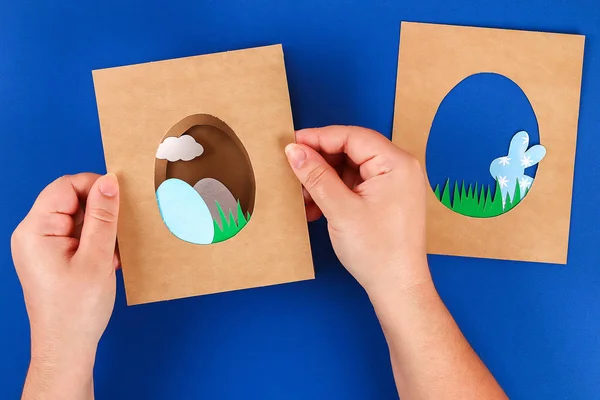 Diy tarjetas de Pascua de papel. Volumen tarjetas de felicitación con un conejo, huevo sobre fondo azul. 3d . — Foto de Stock