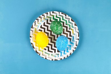 Mavi bir arka plan üzerinde renkli pilavlı DIY Paskalya yortusu yumurta boyalı. Yumurta Paskalya için dekor