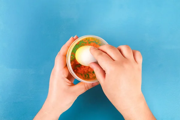Diy Easter egg painted with colored rice on a blue background. The decor of eggs for Easter — Stock Photo, Image