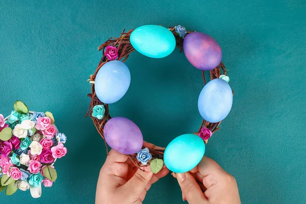 Grinalda de Páscoa Diy de galhos, ovos pintados e flores artificiais em um fundo verde . — Fotografia de Stock