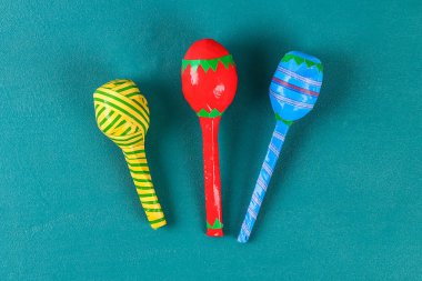 Diy cinco de mayo maracas from eggs, spoons and cereals on a green background. clipart