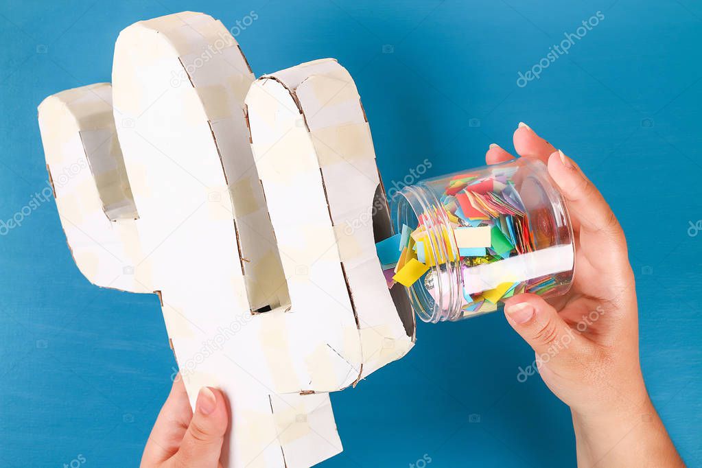 Diy cinco de mayo Mexican Pinata Cactus made cardboard, crepe paper your own hands blue background