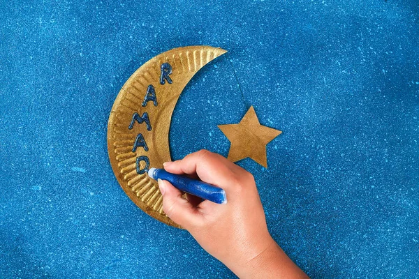 Diy Ramadan kareem luna creciente con una estrella de una placa de cartón desechable y pintura de oro . —  Fotos de Stock