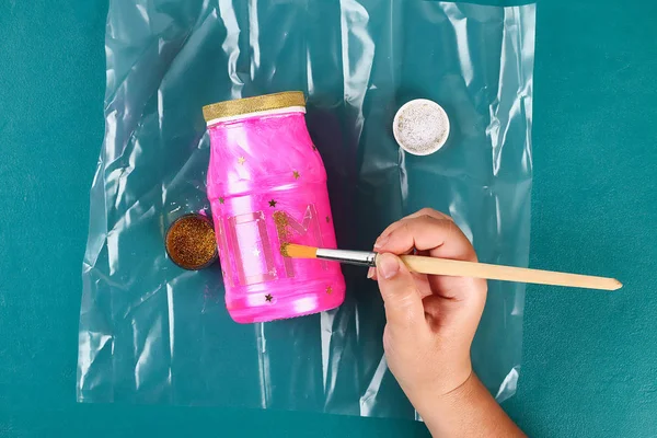 Diy Anneler Günü vazo bir cam kavanoz, pembe boya, parıltı, yıldız, altın bir kurdele metin ile