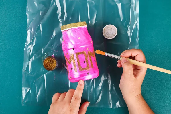 Diy Mothers Day vase with text from a glass jar, pink paint, sparkles glitter, stars, a gold ribbon — Stock Photo, Image