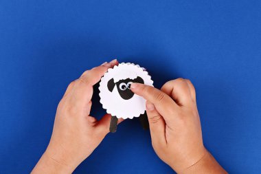 Diy Eid al adha kuzu koyun tatlı şeker kağıt, mavi arka plan üzerinde dondurma için ahşap çubuklar