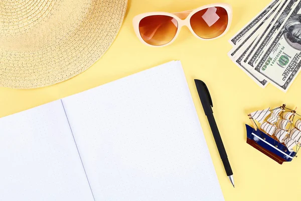 Bloc de notas fondo amarillo, gafas de sol, sombrero, dinero. Espacio superior view.copy. Fondo de verano, viajes . — Foto de Stock