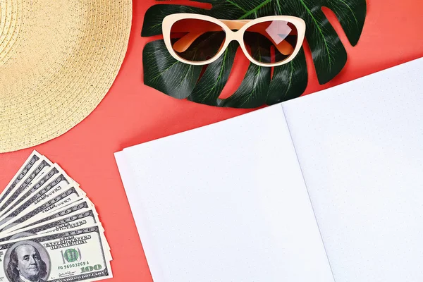 Bloc de notas fondo coral, gafas de sol, sombrero, dinero. Vista superior, espacio de copia. Fondo de verano, viajes . — Foto de Stock