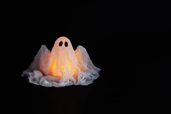 Halloween ghost of starch and gauze on black background. Gift idea, decor Halloween.