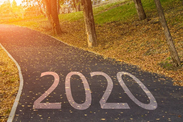 Concept yeni yıl 2020 için. Word 2020 orta asfalt yol altın günbatımı karayolu yolu üzerinde yazılmış. — Stok fotoğraf