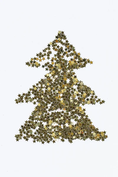 Layout natalizio. Confetti dorati a forma di stelle piegati a forma di albero di Natale — Foto Stock