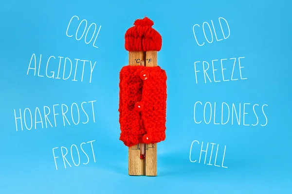 Thermomètre en bois, coiffé d'un chapeau rouge et d'un pull sur fond bleu — Photo