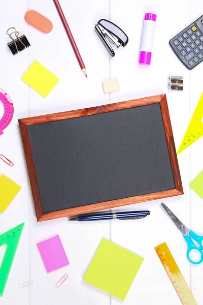 Schoolbord omringd door briefpapier op witte houten tafel. Kopieer de ruimte. — Stockfoto