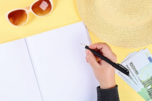 Notepad fundo amarelo, óculos de sol, chapéu, dinheiro. Topo view.copy espaço. Fundo de verão, viagem . — Fotografia de Stock