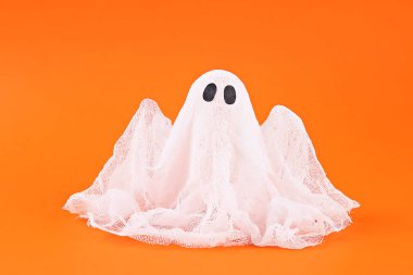 Turuncu arka planda nişasta ve gazlı bez Halloween hayalet. Hediye fikir, dekor Halloween.