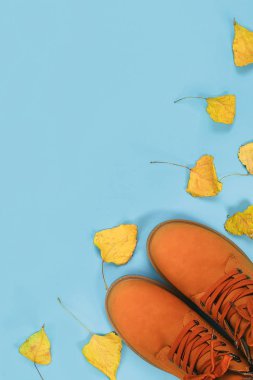 Turuncu kahverengi erkek sonbahar bir mavi pastel arka plan üzerinde botlar. Üstten görünüm, kopya alanı.