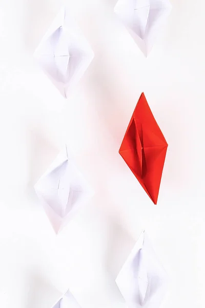 Barca di carta rossa tra gli altri bianchi. Leadership, corvo bianco, individualita '. Origami. Vista dall'alto, piatta — Foto Stock