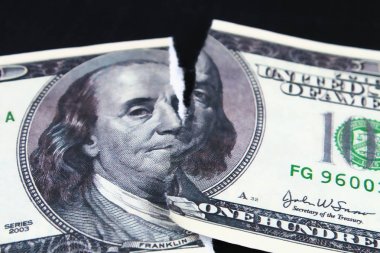 Yırtılmış 100 dolarlık banknotun değerini düşürmüş. dolar çöküşü. Devalüasyon. Düşen para birimi