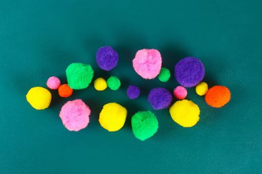 Bir teal arka plan üzerinde renkli güzel pompons. Pompon çeşitleri.