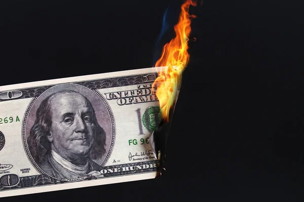 one hundred American dollar burning in fire flame. collapse of dollar. Devaluation. Falling currency