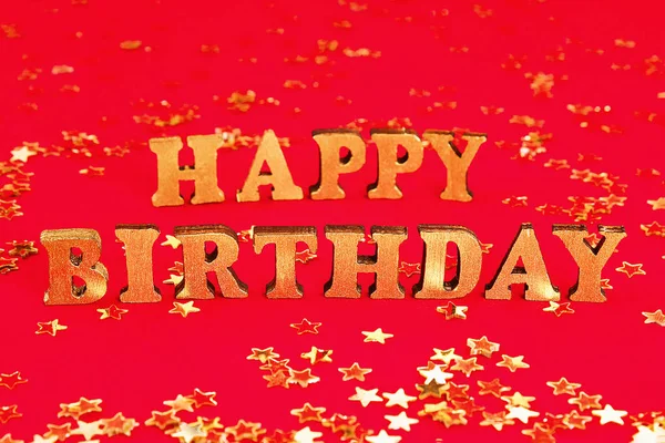 Tekst Happy urodziny ułożone z złotych liter na pięknym tle. Złote gwiazdki konfetti. — Zdjęcie stockowe