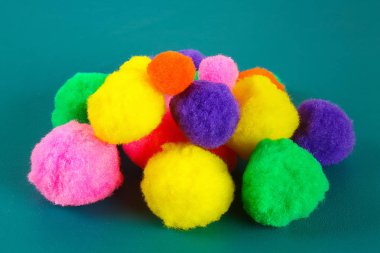 Bir teal arka plan üzerinde renkli güzel pompons. Pompon çeşitleri.