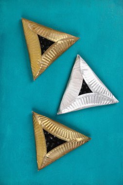 Purim. Kurabiyeler mavi arka planda hoş bir sürprizle karton tabaklardan yapılmış. Çocuklar için hediye fikirleri, Purim için dekor. El yapımı. Adım adım. Çocuk el sanatları süreci. Üst görünüm.