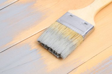 Elinde boya olan fırça. Bir adam gri boya fırçasına tahta çiziyor..