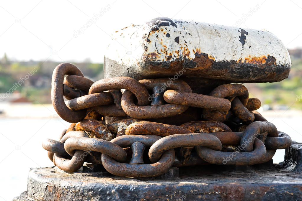 rusty anchor chain around the mooring bollard