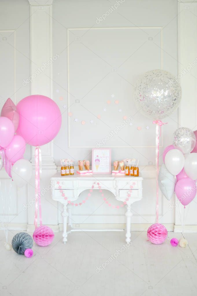 Decorations for holiday party. A lot of balloons pink and white colors. Cakes and drinks for birthday decorations. 